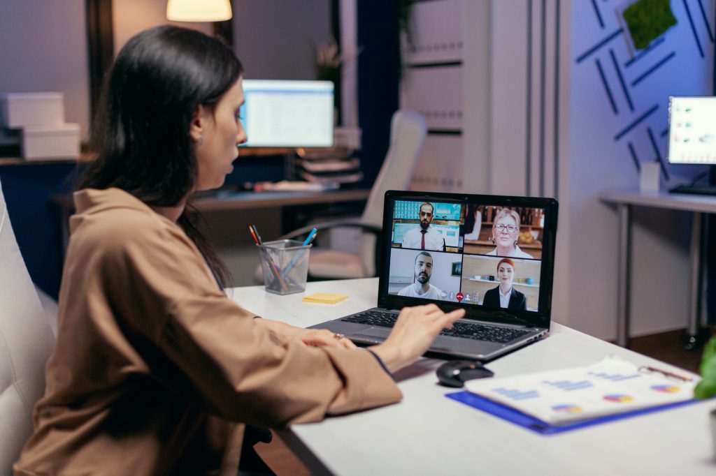 Businesswoman leading a video conference call late night